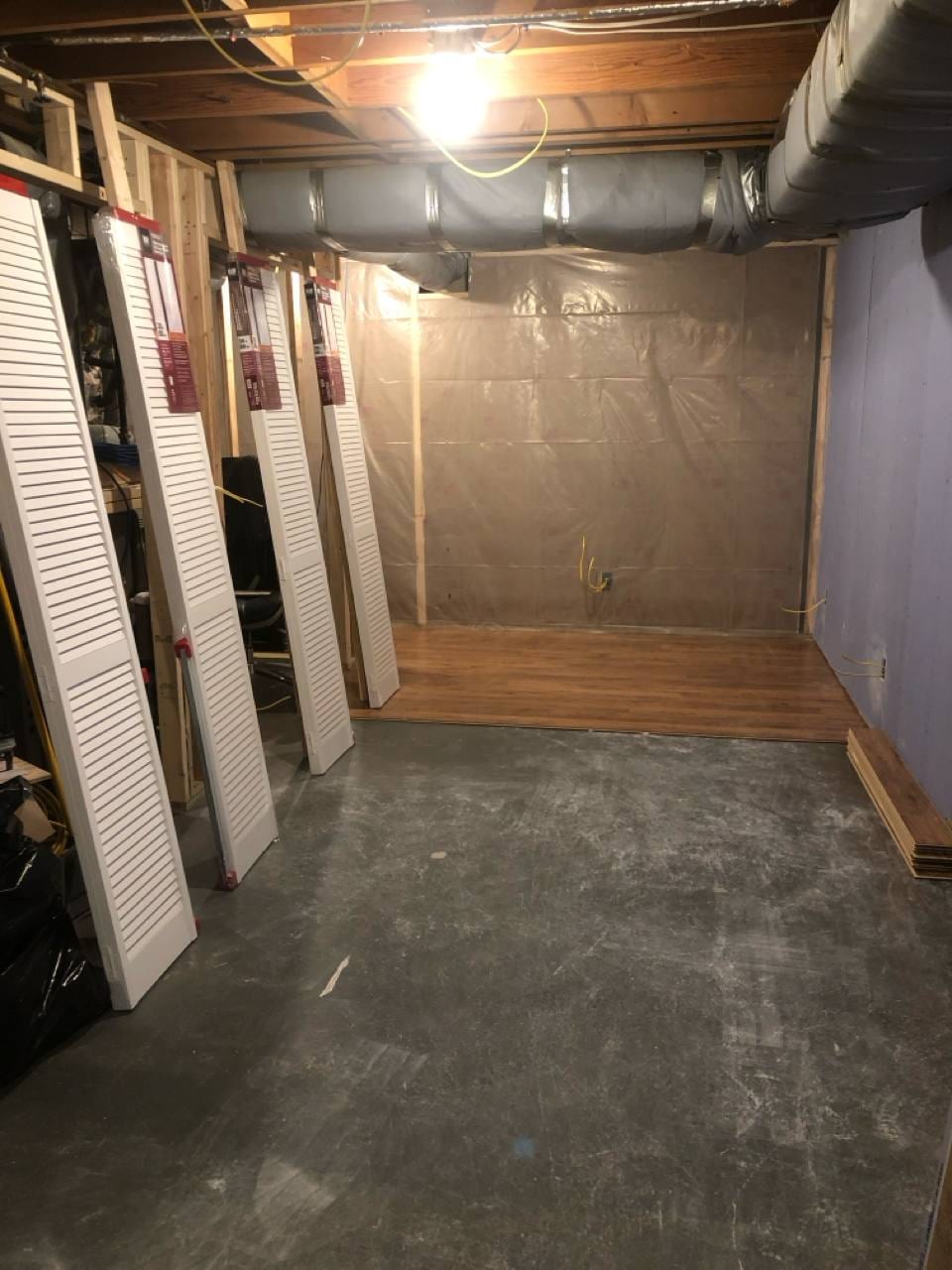 Basement mid-project with insulation, vapor barrier, and flooring going in